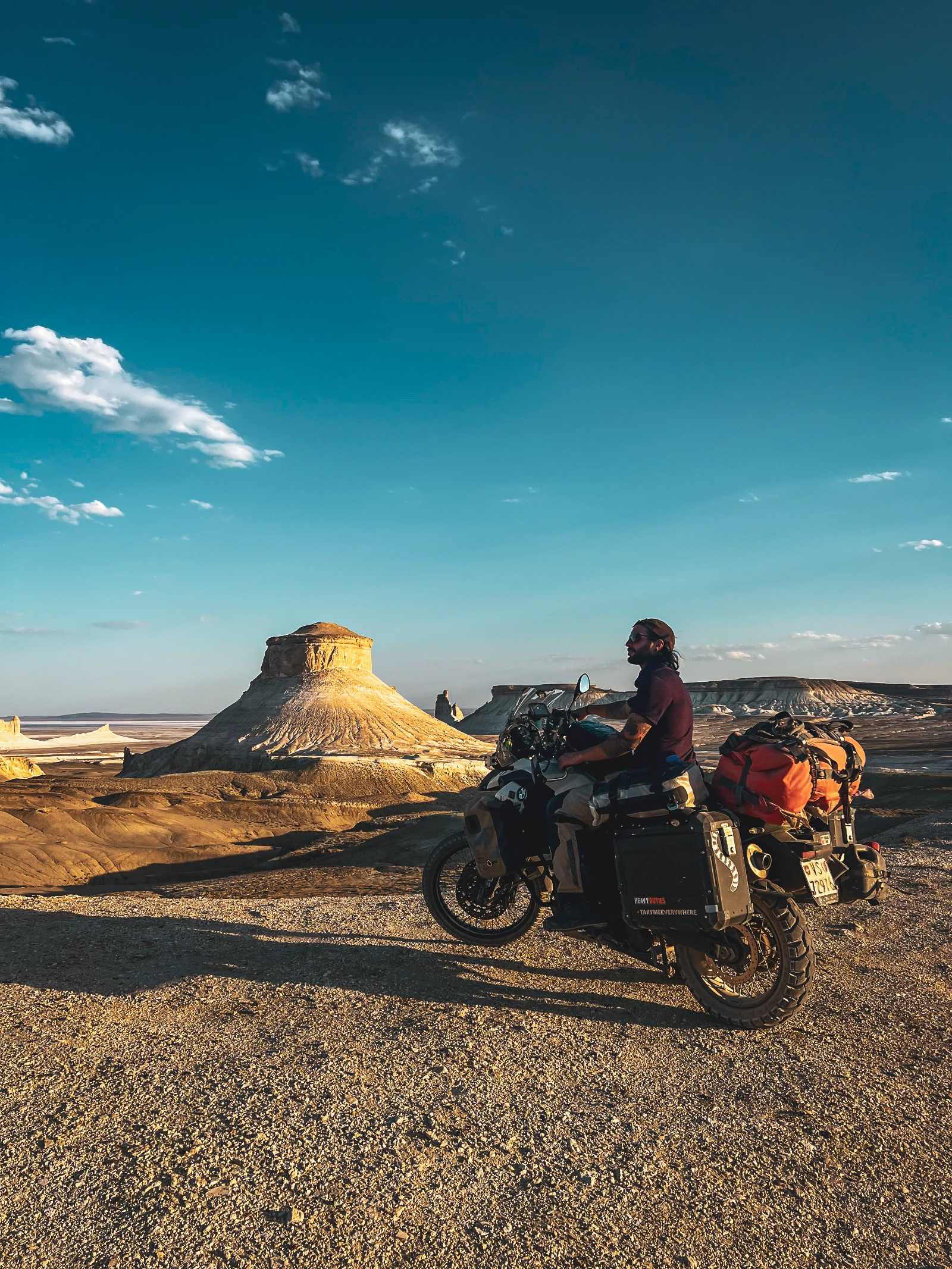 Motorcycle riding through the white chalk pistes near Bozjyra, Kazakhstan