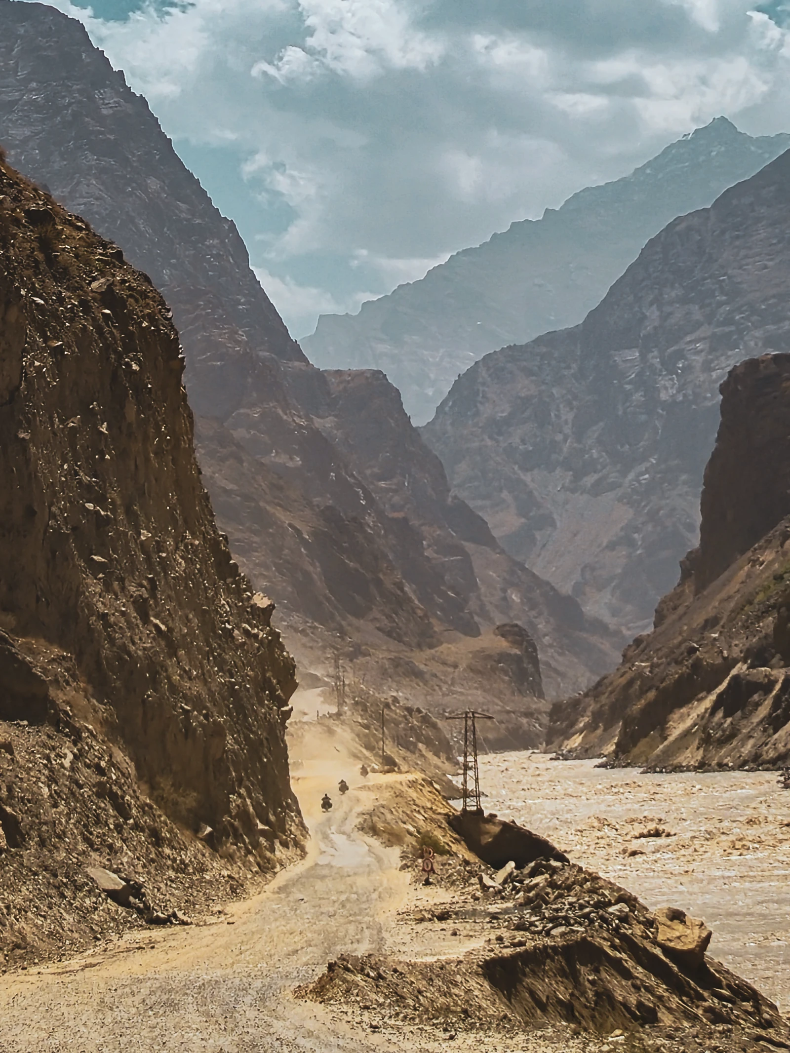 Riding along the Panj River on the Pamir Highway, Afghanistan on the other bank