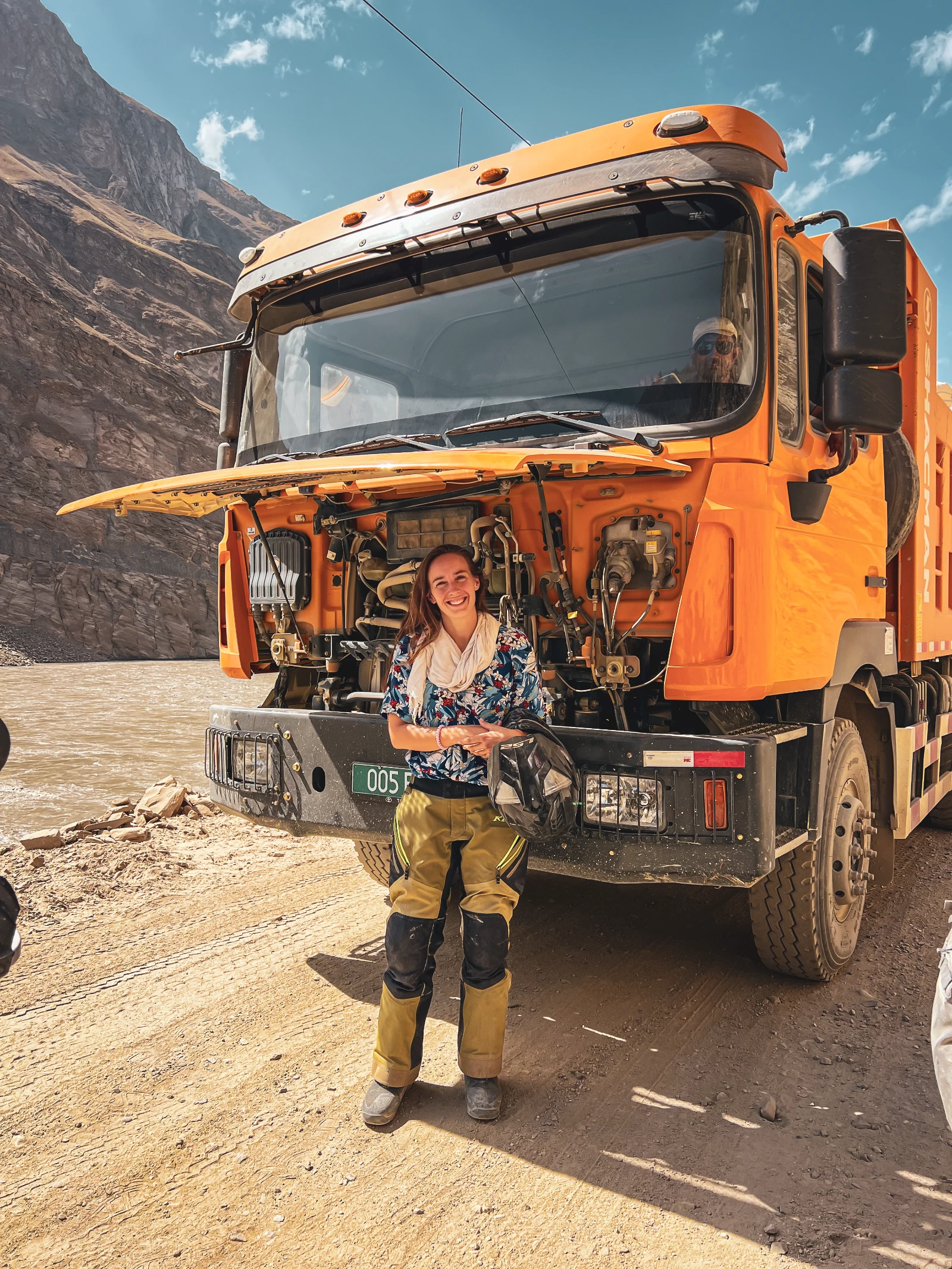 Natha sheltering under a truck hood from the Pamir heat