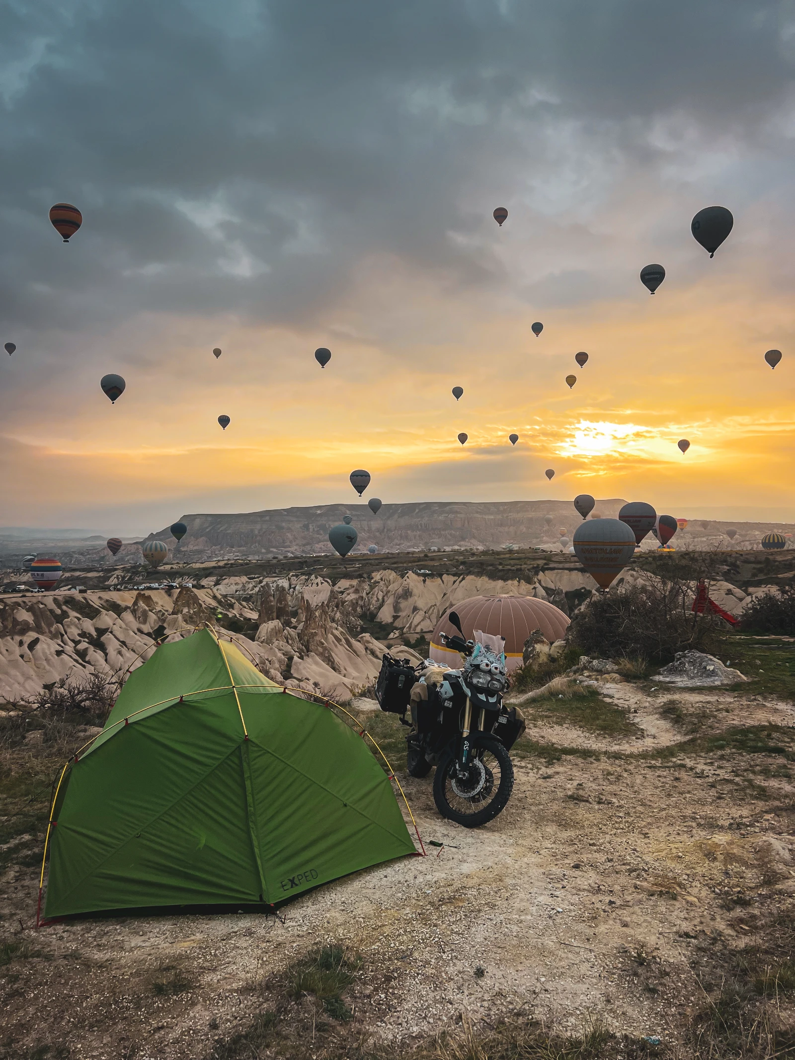 Sunrise over Cappadocia bivouac with hot air balloons on our Turkey by motorcycle route
